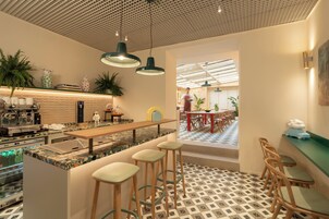 Un caffè moderno con bancone, posti a sedere e pavimento decorato.