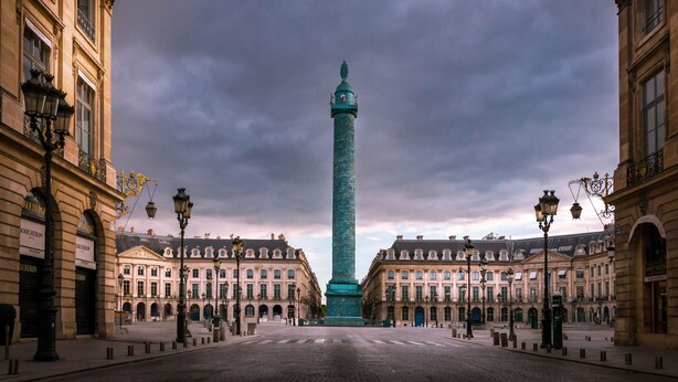 A historic square with a central monument, classical architecture, and a paved ground. - Maison Barrière Vendôme (Paris)