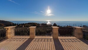 Un balcon avec vue sur la mer et un ciel dégagé.