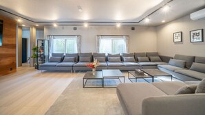 Una sala de estar moderna con un sofá seccional, una mesa de centro y un ventanal que proporciona luz natural.