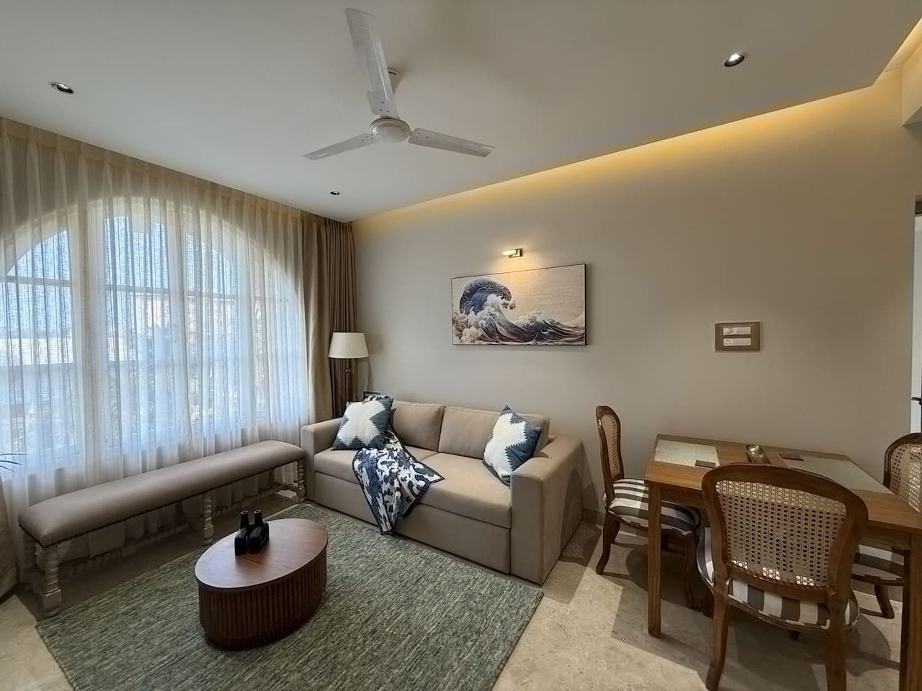 A living room with a sofa, coffee table, and dining area.
