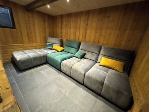 Ein Zimmer mit einer Eckcouch, einem kleinen Tisch und einem Fenster.