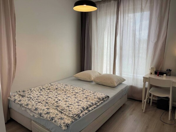 A small, neatly arranged bedroom with a bed, a desk, and a chair. - Room-cozy 3 Bedroom Apartment in Heart o (Espoo)