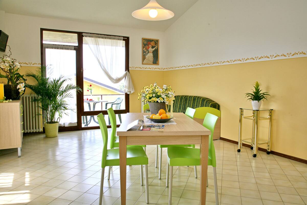 A dining area with a table, chairs, and a potted plant.