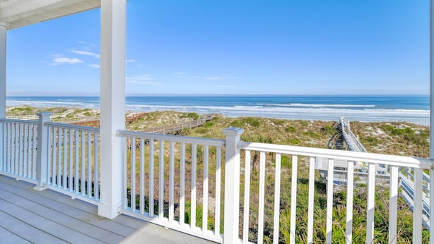 A covered deck with white railings overlooking a beach with dunes and a clear blue sky. - Oceanfront Family Escape! Two Balconies, Private Boardwalk to Beach, Hot Tub! $300 in Free Tickets! (Saint Augustine)