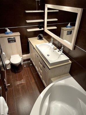 A modern bathroom with a white sink, a mirror, a toilet, and a bathtub. - Appt 8p, ski-in, ski-out, parking (Les Allues)