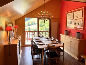 A dining area with a table set for six, a chandelier, and a view of the outdoors. - Appt 8p, ski-in, ski-out, parking (Les Allues)