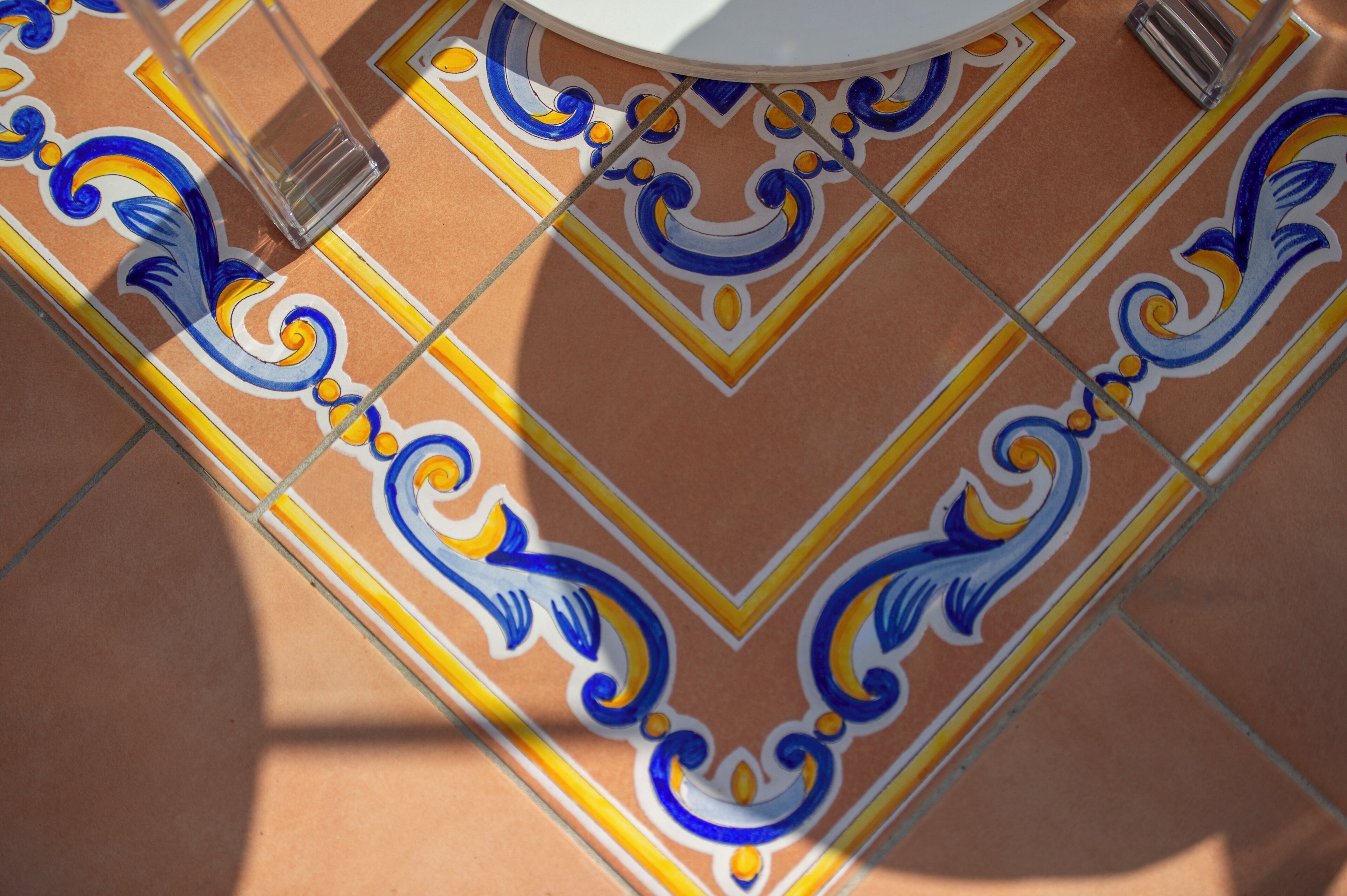 A close-up of a tiled floor with intricate blue and yellow patterns.