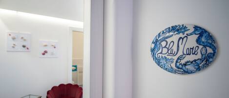 A room with a red chair, a small table, and a wall-mounted sign that reads "Blue House."