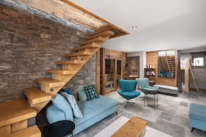 A modern interior with a wooden staircase, a sofa, and a chair. - L'Edelweiss - Luxury chalet with Jacuzzi & Sauna, Gérardmer (Gérardmer)