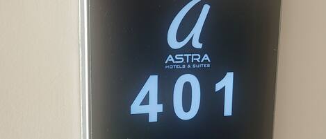 A digital key card for Astra Hotels & Suites with room number 401, featuring icons for room service, housekeeping, and a do not disturb symbol.