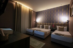 Habitación triple Deluxe, vistas al jardín | Minibar, caja fuerte, escritorio y espacio para trabajar con un portátil