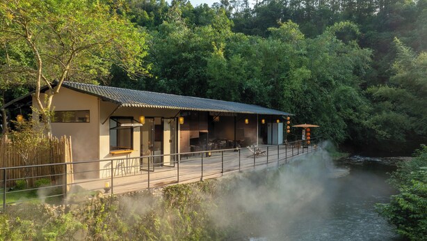 A traditional-style building with a wooden deck overlooking a river, surrounded by lush greenery. - Xiyang Yishan Quiet Private Onsen Country Style Vacation Courtyard (Qingyuan)
