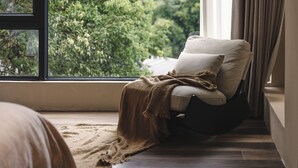 A cozy room with a large window, a comfortable chair, and a view of greenery outside. - Xiyang Yishan Quiet Private Onsen Country Style Vacation Courtyard (Qingyuan)