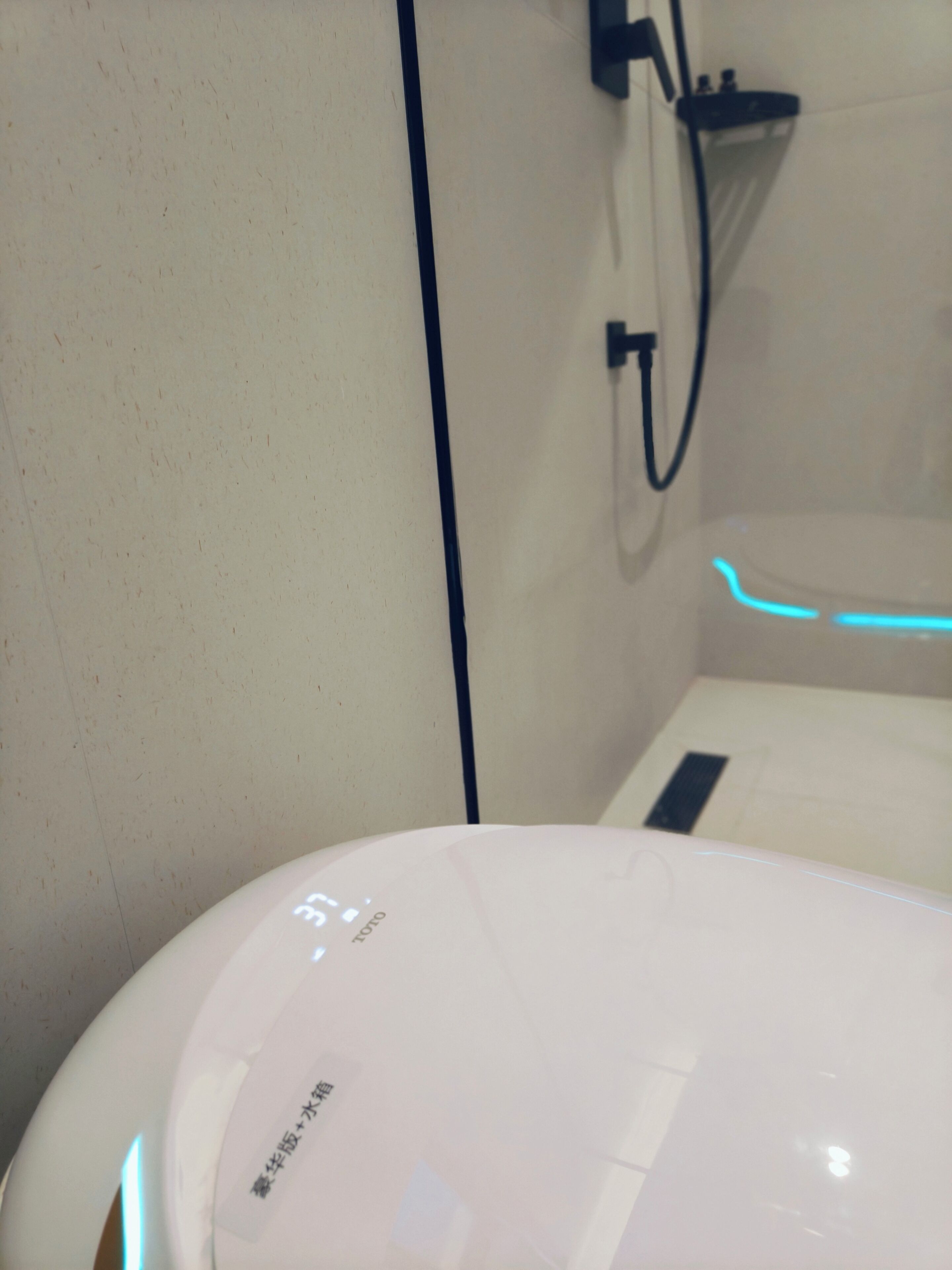Un bagno moderno e luminoso con scaldabagno a vista e zona doccia illuminata di blu.