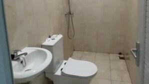 A small, tiled bathroom with a shower, toilet, and sink. - Slara Hostel Syariah 1 (Bandar Lampung)