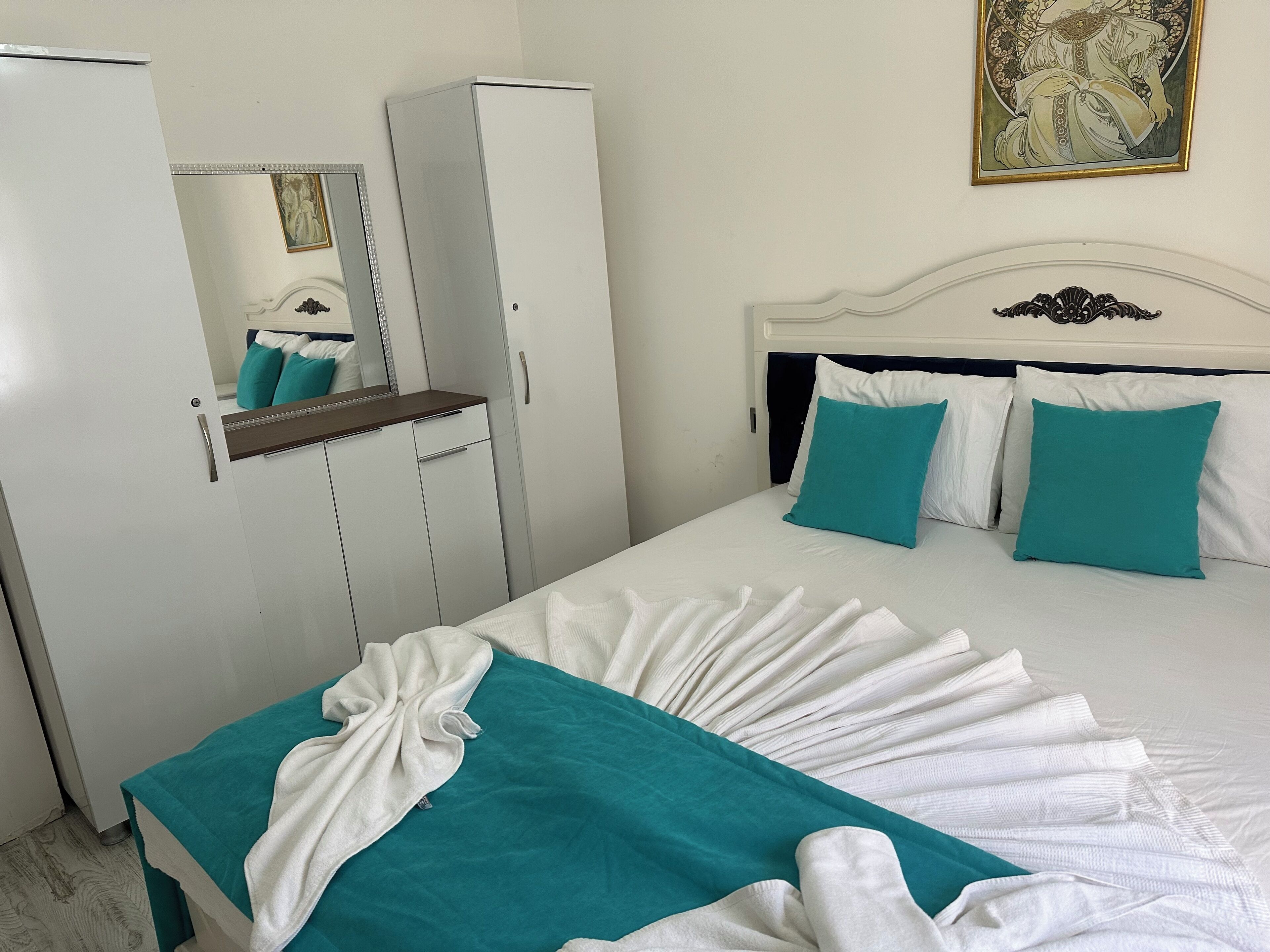 Una habitación de hotel con cama, armario y espejo.