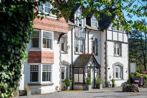 A traditional building with multiple windows and a stone foundation. - Stanley House (Holmrook)