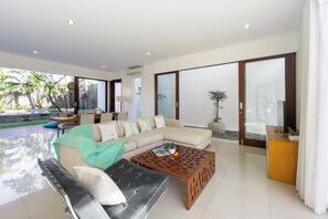 A modern living room with a sectional sofa, a coffee table, and a TV stand.