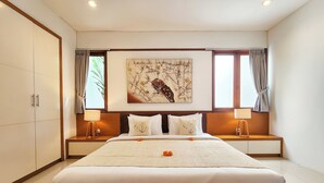 A modern hotel room with a large bed, two bedside tables with lamps, a wall-mounted artwork, and a view of the outdoors through the windows.