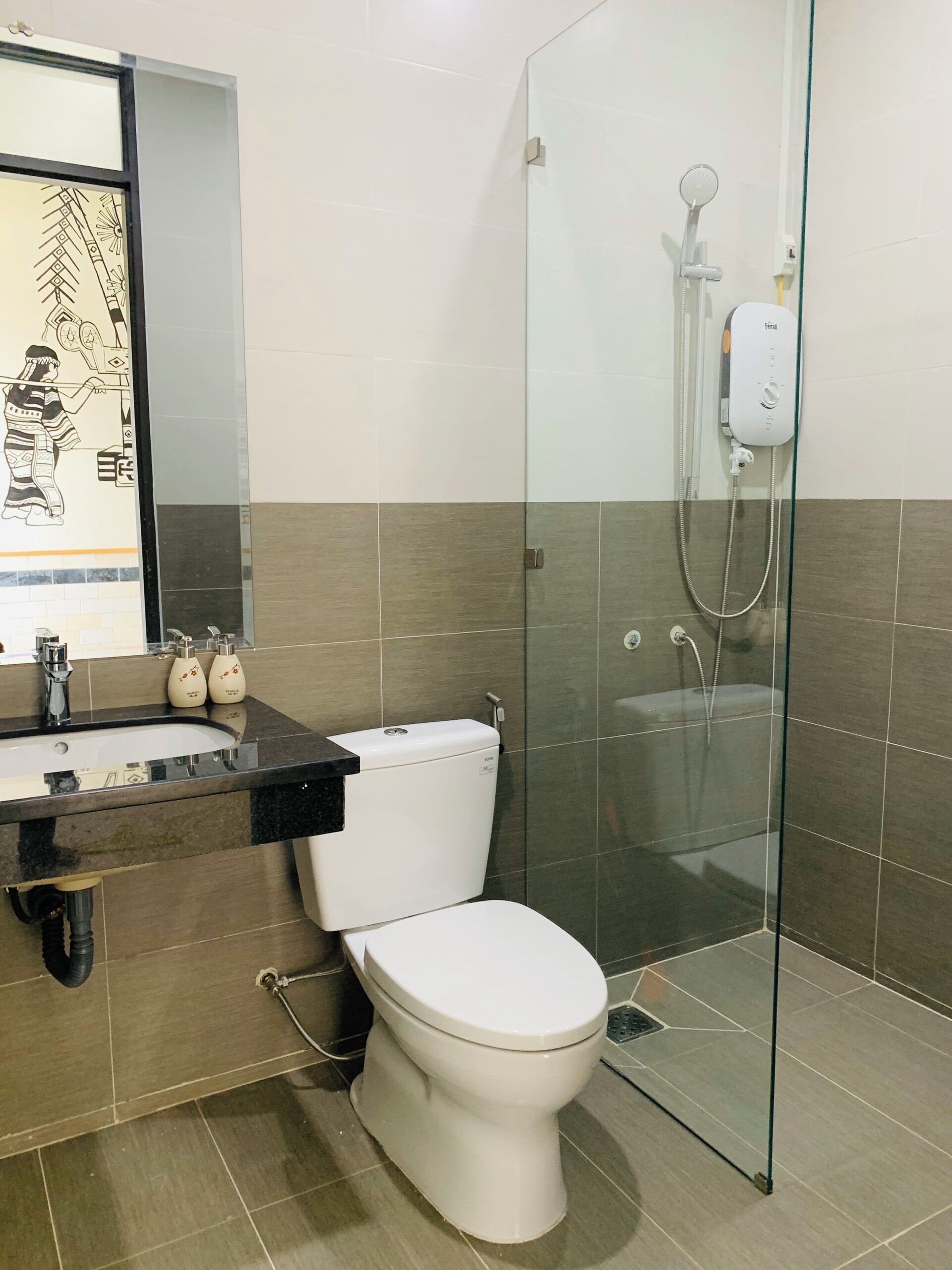 A modern bathroom with a glass shower enclosure, a toilet, and a sink with a black countertop.