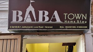 Entrada de un hotel con un letrero que dice "BABA TOWN Home Stay".