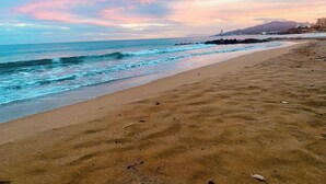 A beach with a rocky shoreline and a clear sky. - Cozy Beachside Haven (Pulpi)