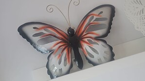 A wall-mounted butterfly decoration. - Cozy Beachside Haven (Pulpi)