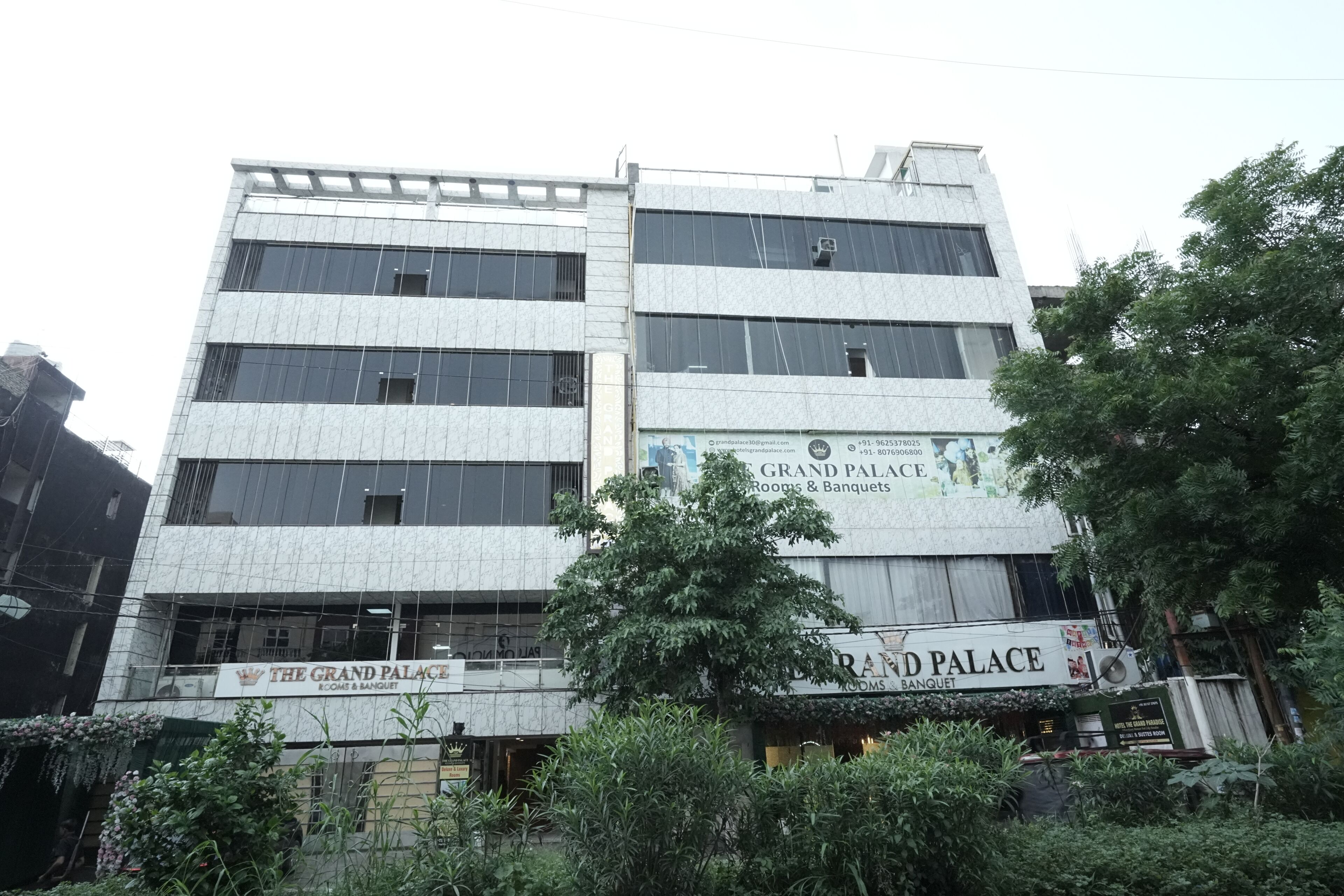 A multi-story building with signage for 'The Grand Palace' and 'Grand Palace Rooms & Banquet'.