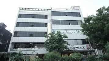 A multi-story building with signage for 'The Grand Palace' and 'Grand Palace Rooms & Banquet'.