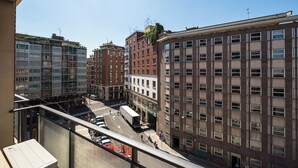 Een meerhoog gebouw met een combinatie van woon- en commerciële ruimtes, met een straatbeeld met voertuigen en voetgangers.