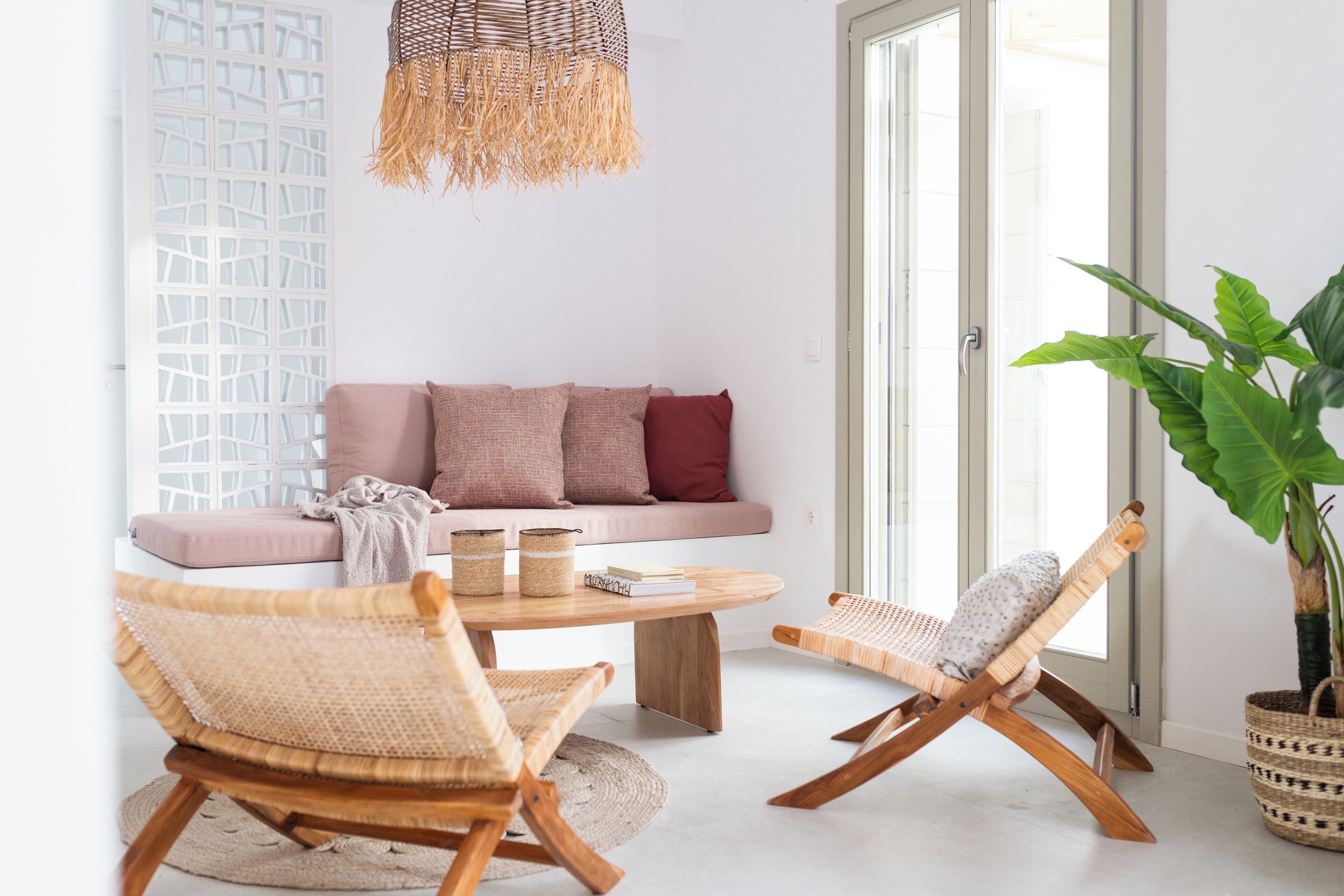 Ein modernes Wohnzimmer mit einer Couch, zwei Schaukelstühlen, einem Couchtisch und einer großen Pflanze.