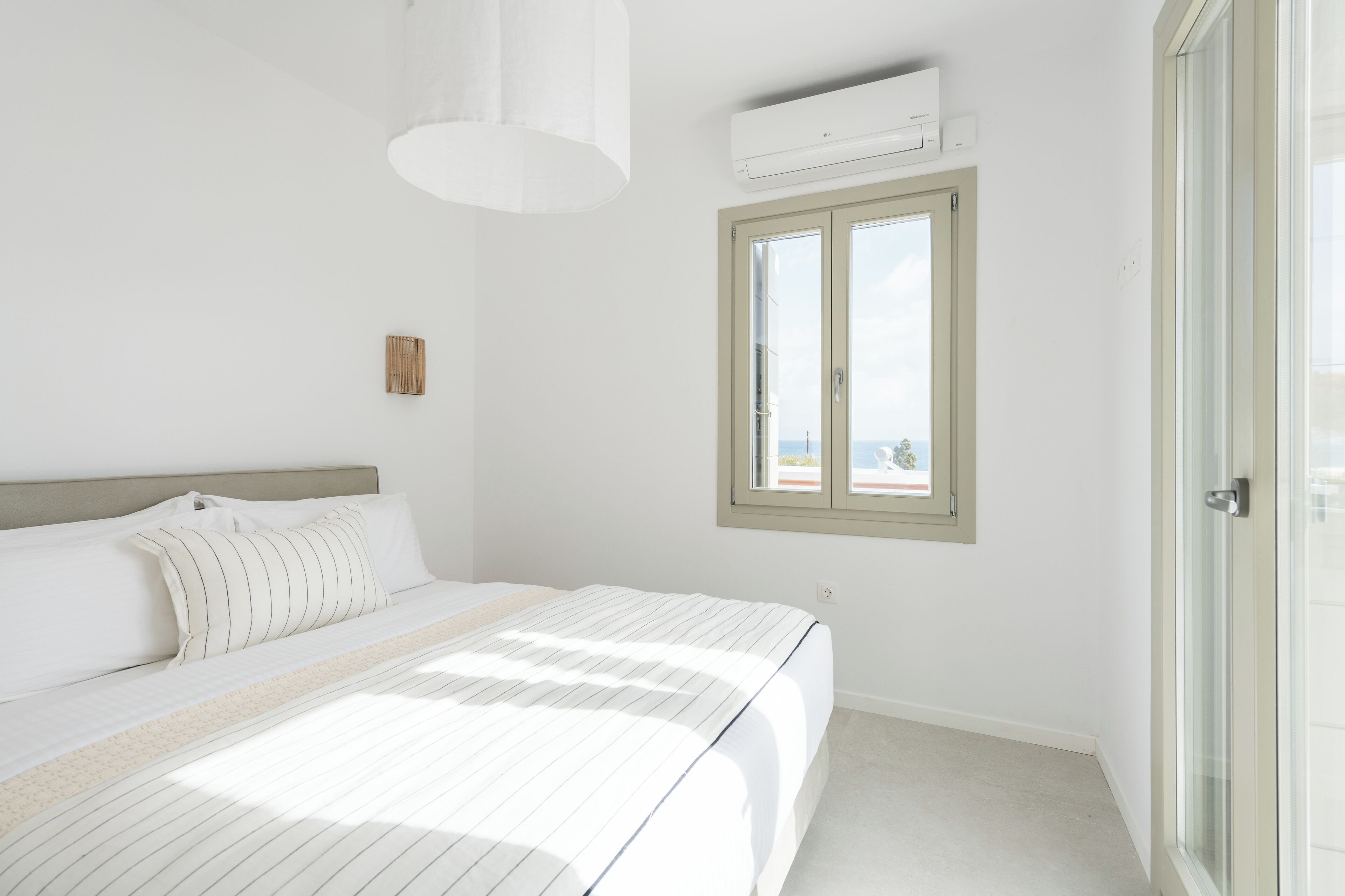 Une chambre à coucher avec un lit, une fenêtre et un appareil de climatisation.