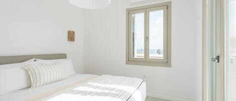 Une chambre à coucher avec un lit, une fenêtre et un appareil de climatisation.