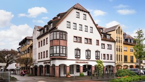A multi-story hotel with a classic European architectural style, featuring a prominent corner turret and arched windows. - ARKADEN Hotel Kelkheim (Kelkheim)