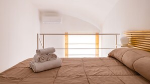 A bedroom with a bed, a window, and a wooden headboard. - Materdei Terrace by Napoliapartments (Naples)