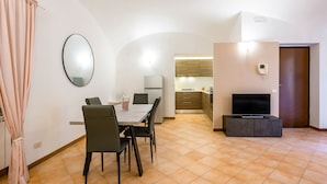 A modern apartment with a dining area, kitchen, and living space. - Materdei Terrace by Napoliapartments (Naples)