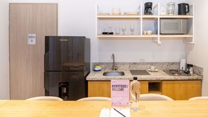 A modern kitchen with a black refrigerator, a coffee maker, a microwave, and a sink. There is a welcome sign on the counter. - w* | Pristine 2BR w/ Lovely Terrace in Bocagrande (Cartagena de Indias)
