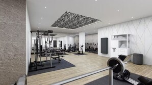 Een moderne sportschool met diverse fitnessapparaten, een houten vloer en een geometrisch plafondontwerp.