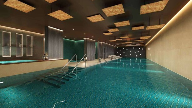 Een modern binnenzwembad met geometrische plafondlampen en een patroon vloer.