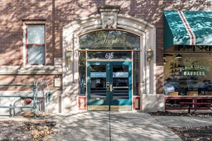 A building with a blue door labeled "The Argyle Apartments" and a "Black Orchid Barbers" sign. - 18BR 17BA Combined Apartments close to Lucas Oil Stadiom (Indianapolis)