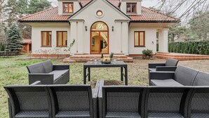 A house with a front porch, outdoor seating, and a dining table set up. - Lumina amazing house in Warsaw (Warszawa BIG)