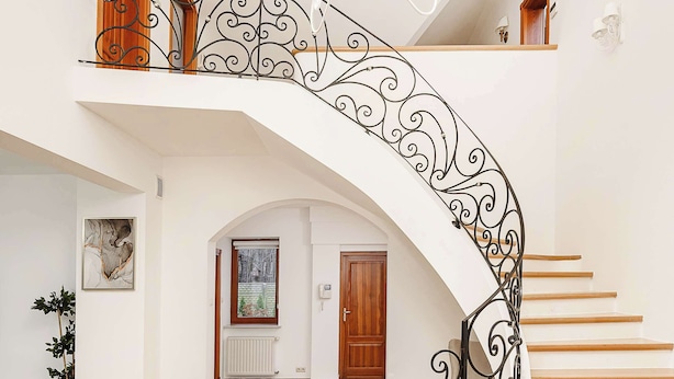 A spacious interior with a curved staircase, a chandelier, and a view of the outdoors through a window. - Lumina amazing house in Warsaw (Warszawa BIG)