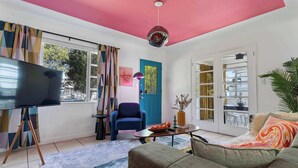 A living room with a TV, sofa, coffee table, and a blue chair. - Retro Rewind, Stylish, Near Design District Miami (Miami)