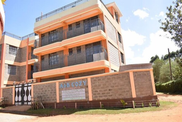 A multi-story building with balconies, labeled "A&B COZY" with amenities including conference and restaurant.