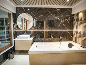 A modern bathroom with a large bathtub, two sinks, a vanity, and a mirror. - Hotel Spencer- Kharghar Navi Mumbai (Panvel)