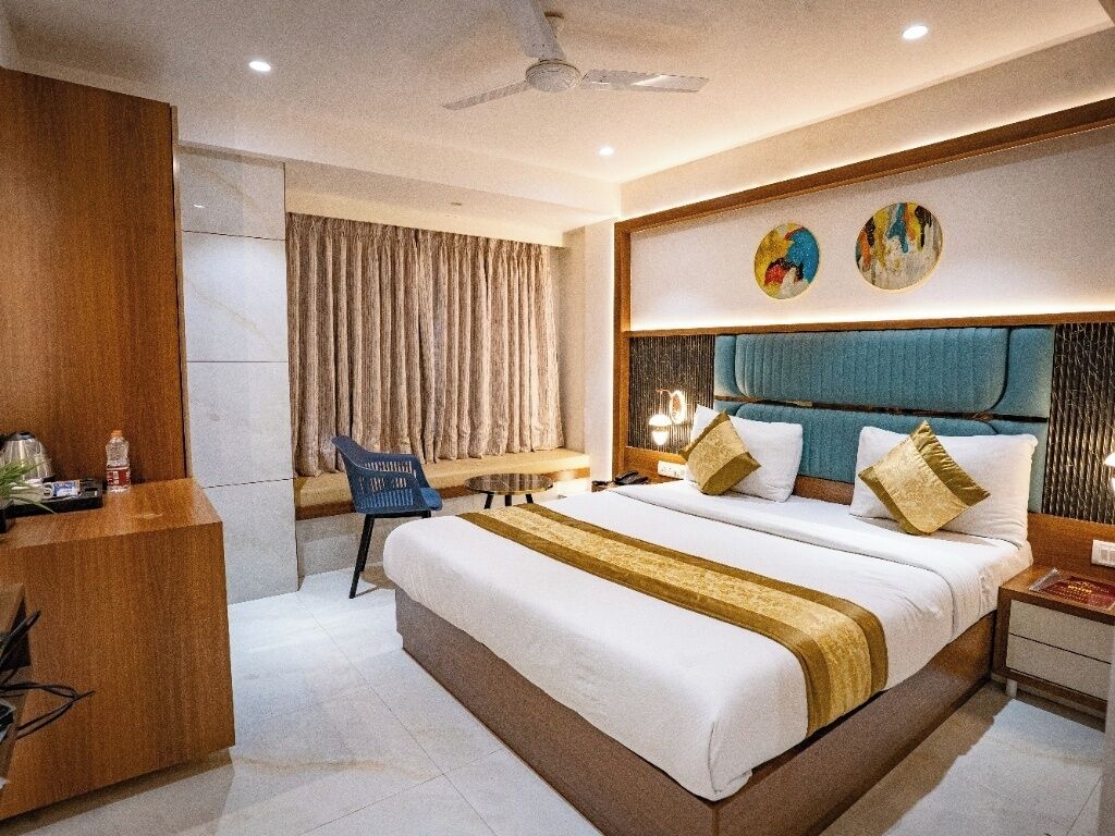 Una habitación de hotel moderna con una cama grande, un escritorio y una silla.
