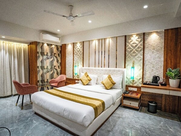 A modern hotel room with a large bed, a desk, and a chair. - Hotel Spencer- Kharghar Navi Mumbai (Panvel)
