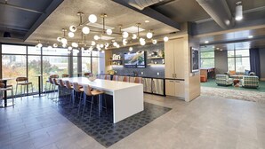 Une cuisine moderne et spacieuse, dotée d’un grand îlot central, d’un coin bar et d’un espace repas avec des chaises.