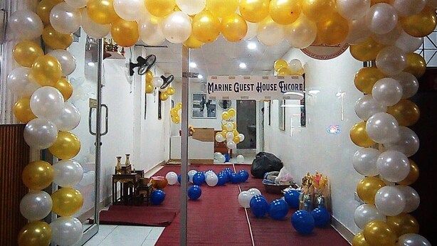 A room with a red carpet, a sign reading "Marine Guest House Encore", and balloons in white and gold. - Marine Guest House Encore (Pattaya)